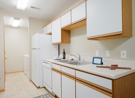 Traditional kitchen with white cabinets, a dishwasher, a sink and a refrigerator