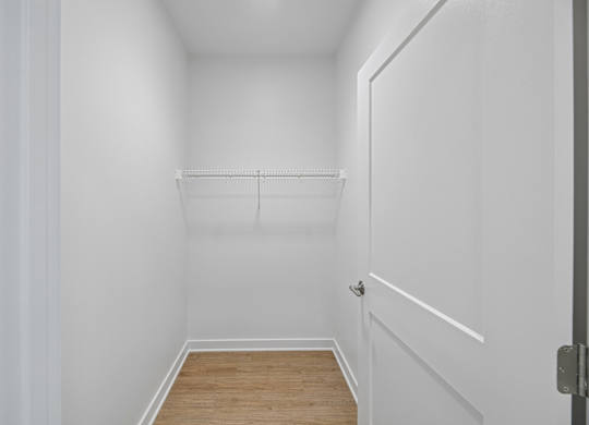 A white hallway with a door on the right.