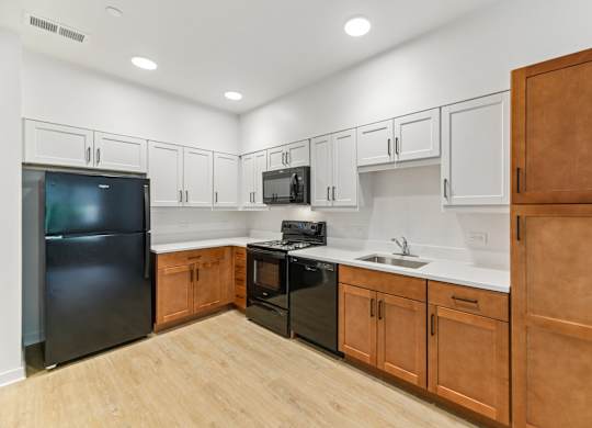 A kitchen with black appliances and wooden cabinets.