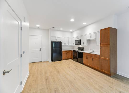 A kitchen with wooden floors and white walls.