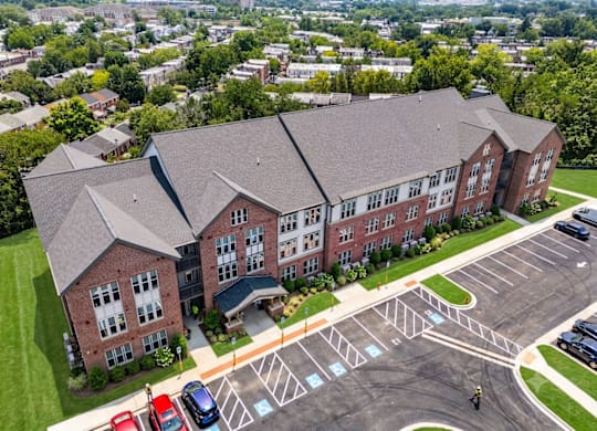 A large red brick building with a parking lot in front.