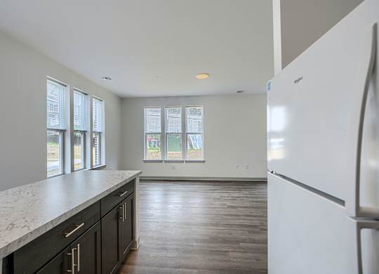 A kitchen with a white fridge and black cabinets.