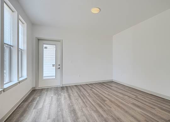 A room with a wooden floor and a white door.