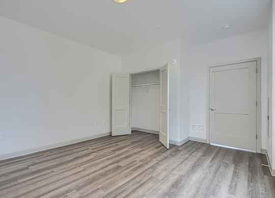 A room with a wooden floor and two white doors.
