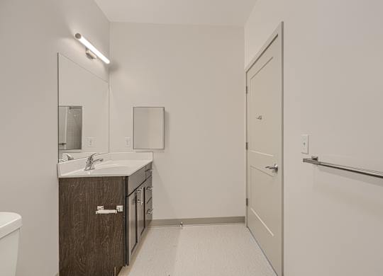 A bathroom with a sink, mirror, and toilet.
