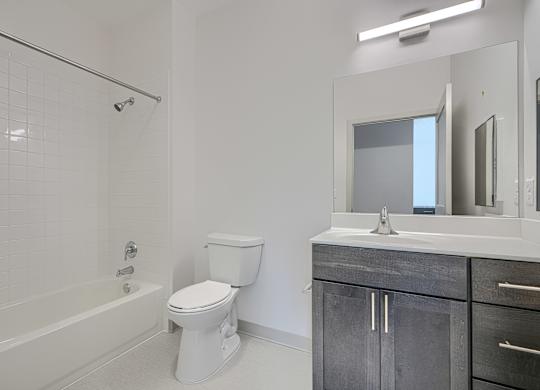 A white bathroom with a toilet, sink, and bathtub.
