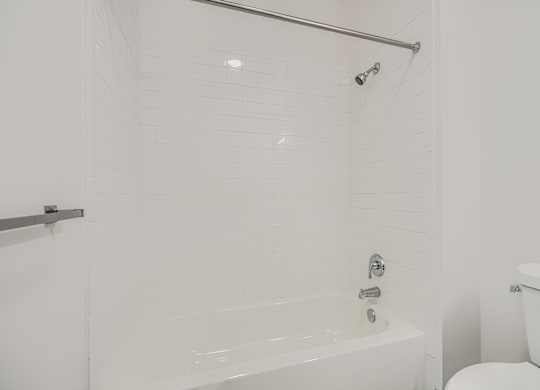 A white bathroom with a tub and toilet.