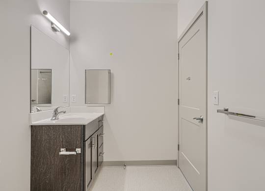 A bathroom with a sink, mirror, and medicine cabinet.