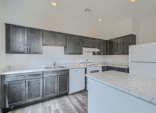 A kitchen with dark wood cabinets and white appliances.