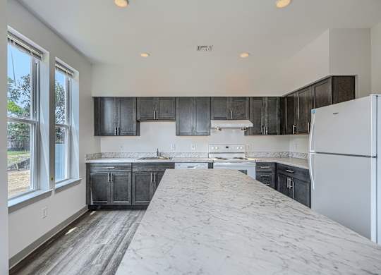 A kitchen with a white fridge and black cabinets.