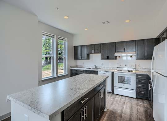 A kitchen with a marble countertop and stainless steel appliances.