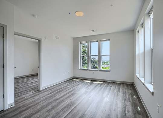 A large empty room with wooden floors and white walls.