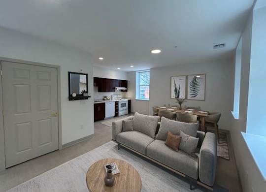A living room with a grey couch and a wooden coffee table.