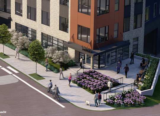 A street view of a building with a flower bed in front of it.