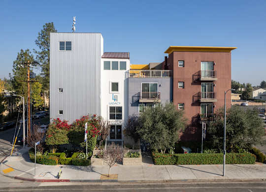 A building with a red roof and a white building with a yellow roof are next to each other.