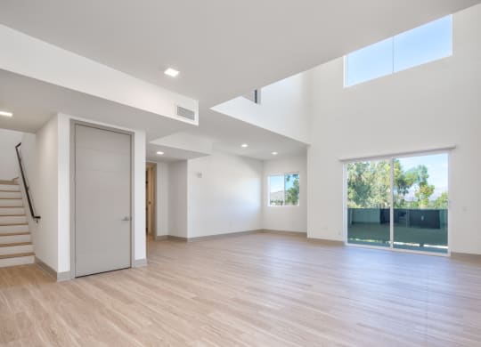 a living room with white walls and a door to a pool