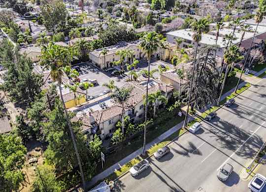 A street view of a residential area with houses and parked cars.