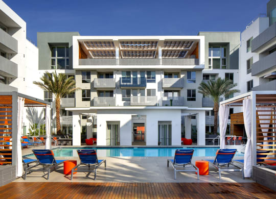 a building with a pool and chairs in front of it