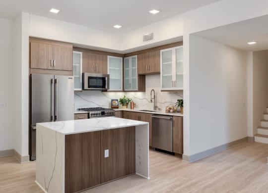 a kitchen with a large island and stainless steel appliances