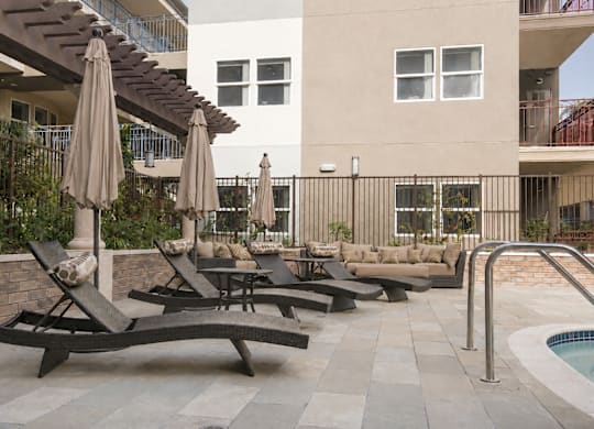 A patio with a pool and a table with chairs.