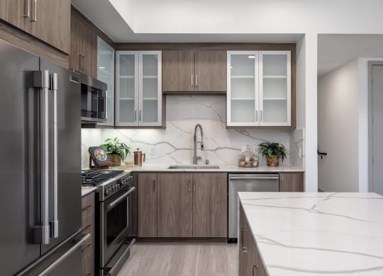 a kitchen with stainless steel appliances and marble counter tops