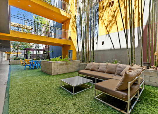 A modern outdoor seating area with a yellow building in the background.