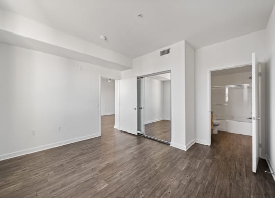 a living room with white walls and a sliding glass door to a bathroom