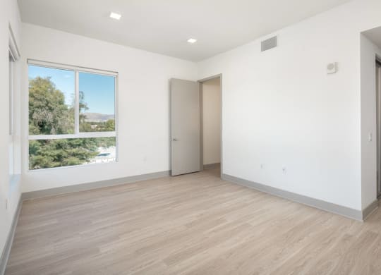 an empty room with white walls and a window