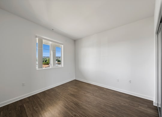 an empty room with white walls and a window