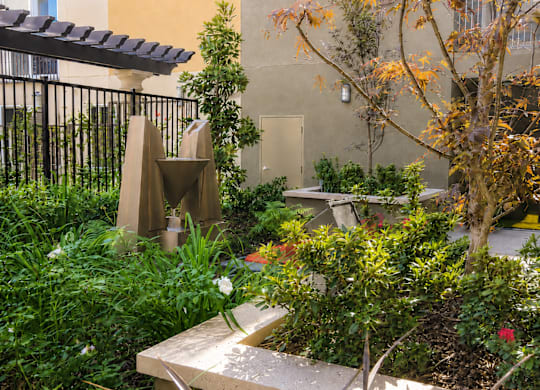 A garden with a bench and a sculpture.