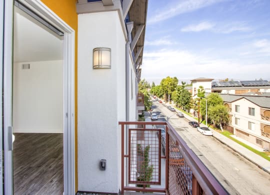 a balcony with a view of the street and a door to a apartment building