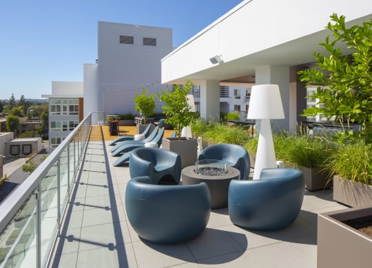 a communal area on the roof of a building with chairs and tables