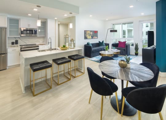 a living room and kitchen with a table and chairs