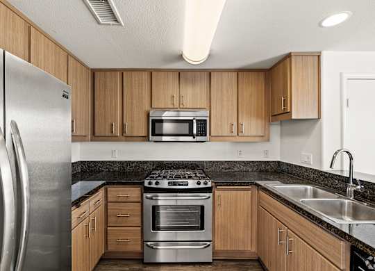A modern kitchen with wooden cabinets and stainless steel appliances.