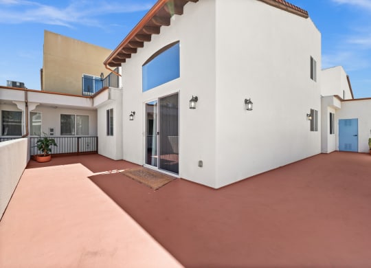 a white house with a patio and a blue door at Le Blanc Apartment Homes, Canoga Park
