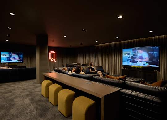 A room with a bar and a television on the wall.