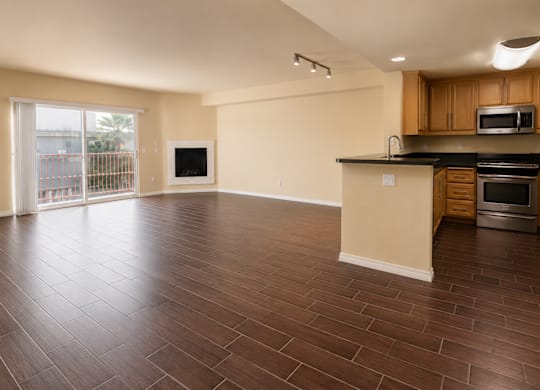 A kitchen with wooden floors and a countertop with a microwave and oven.