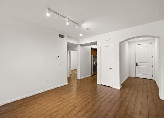 a living room with wood floors and white walls and white doors at Le Blanc Apartment Homes, Canoga Park, CA