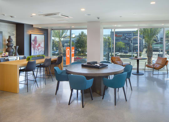 a dining room with a table and chairs in a room with large windows