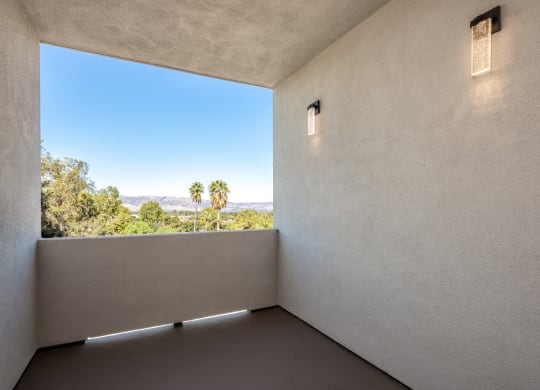 a room with a large window and a view of palm trees
