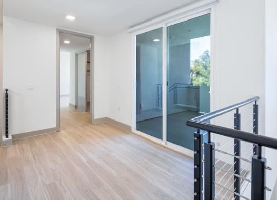 a renovated living room and hallway with sliding glass doors to a balcony