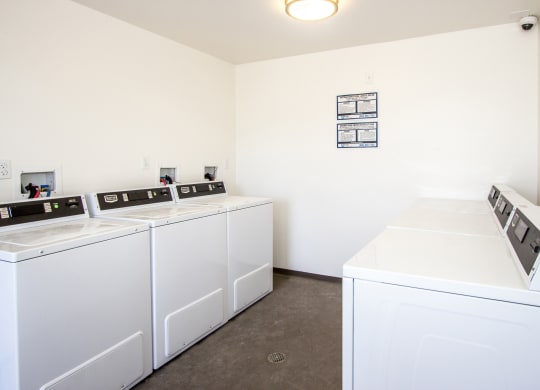a laundry room with four washers and dryers in it