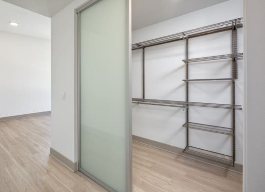 a mirrored closet door in a room with wood floors and white walls