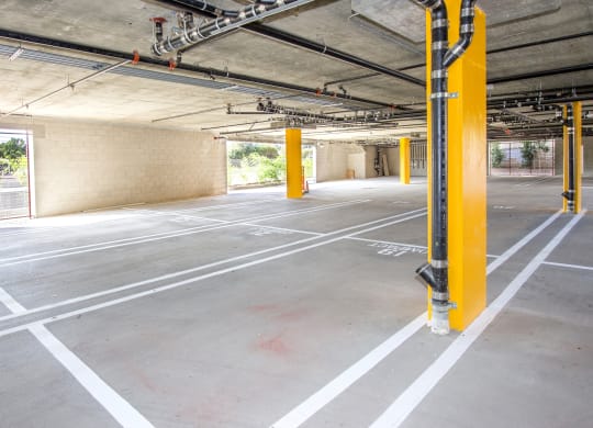 an empty parking lot with yellow poles in a building