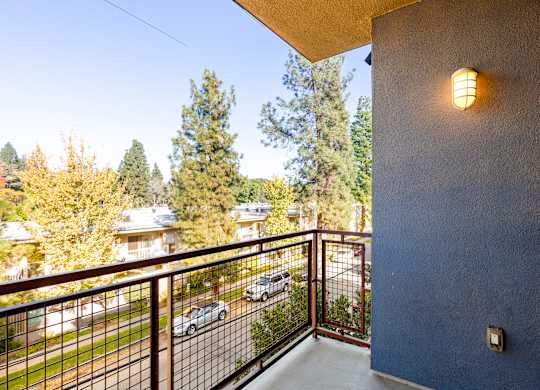 A balcony with a metal railing and a light on the wall.