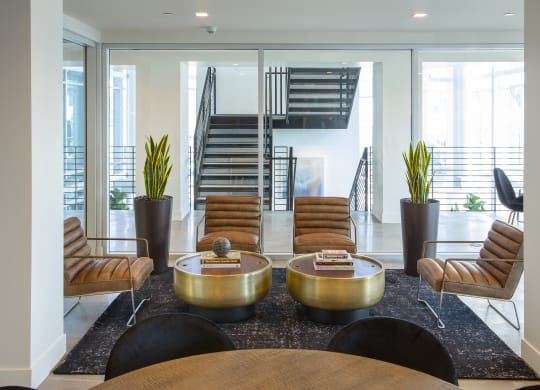a lobby with chairs and tables and a staircase