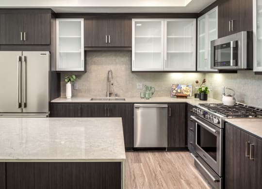 a kitchen with stainless steel appliances and marble counter tops