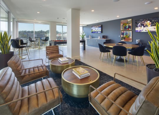 a lounge area with chairs and tables and a television