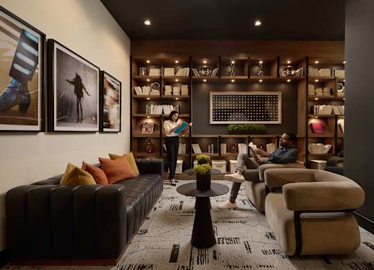 A man is sitting on a couch in a room with a coffee table in front of him.