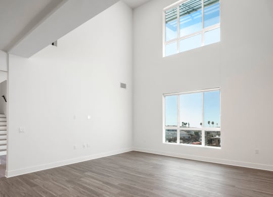 an empty living room with white walls and a large window
